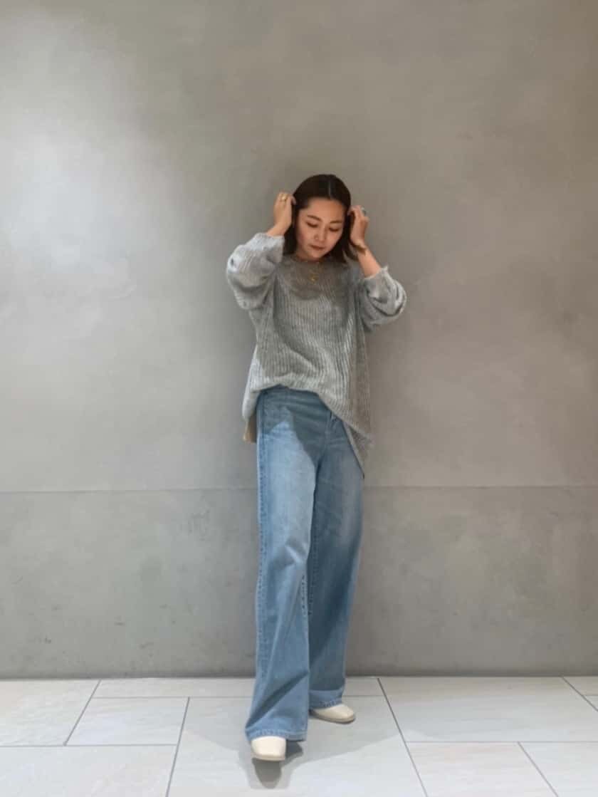 ホワイト系のブーツ、ブルー系のデニムパンツ、グレー系のニット/セーターを着用したレディースの秋コーディネートの2枚目の写真