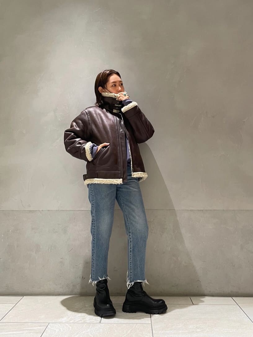 ブラウン系のブルゾン、ブルー系のデニムパンツ、ブルー系のスウェットを着用したレディースの秋コーディネートの5枚目の写真
