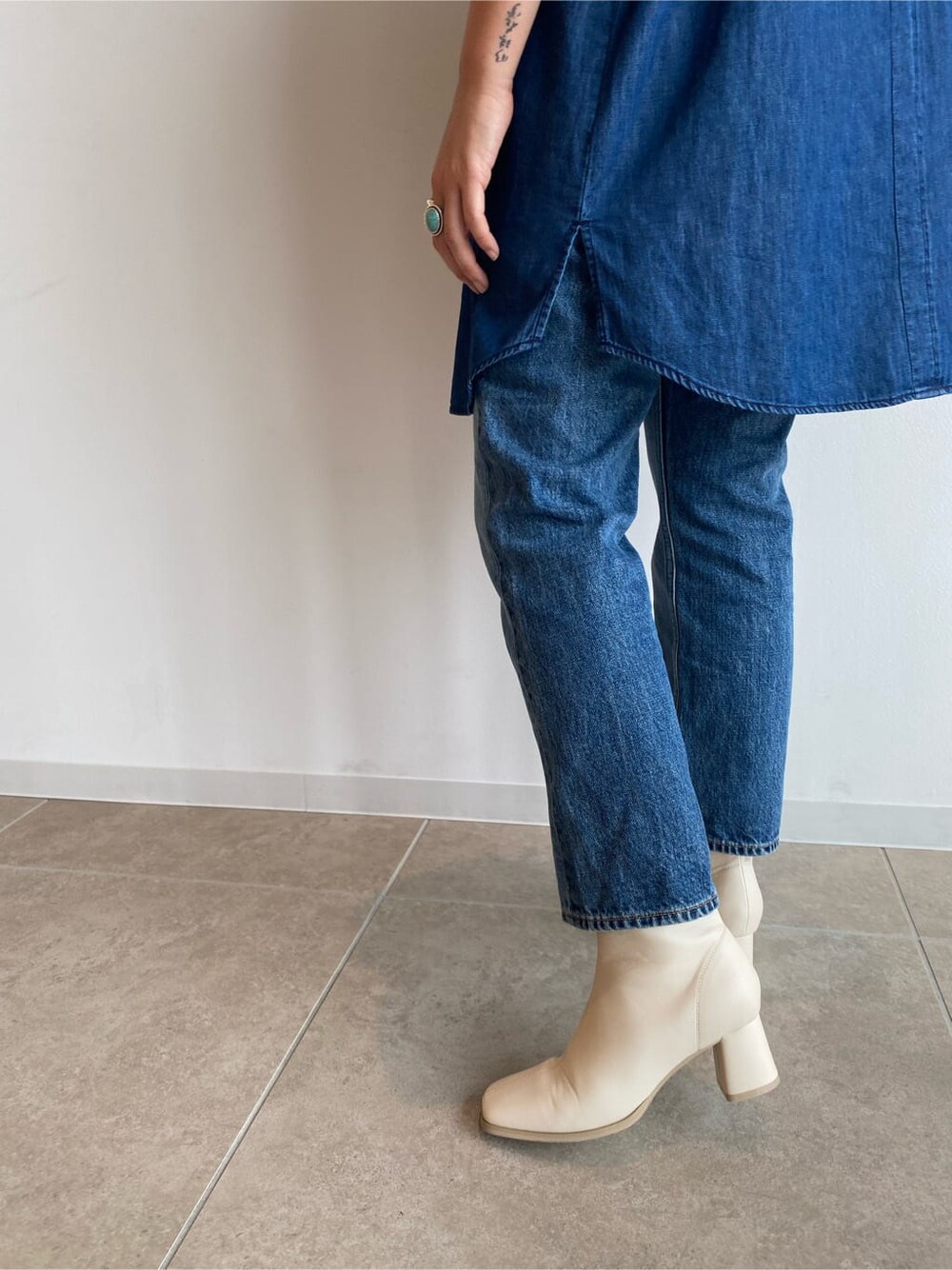 ブルー系のシャツ/ブラウス、ホワイト系のブーツ、ブルー系のデニムパンツを着用したレディースの夏コーディネートの5枚目の写真