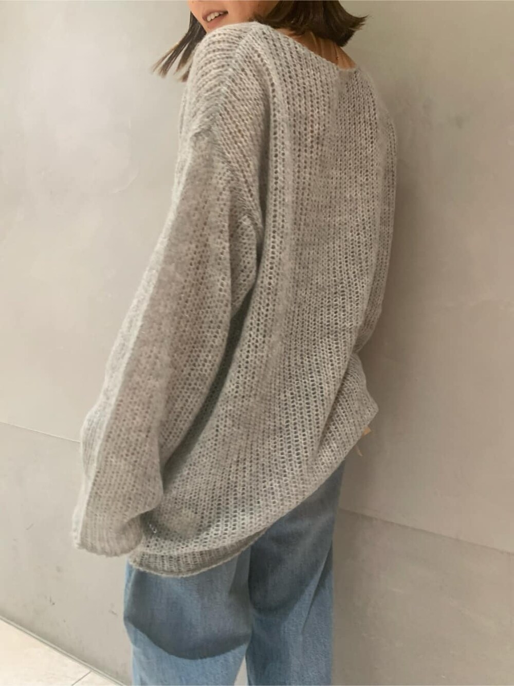 ホワイト系のブーツ、ブルー系のデニムパンツ、グレー系のニット/セーターを着用したレディースの秋コーディネートの5枚目の写真