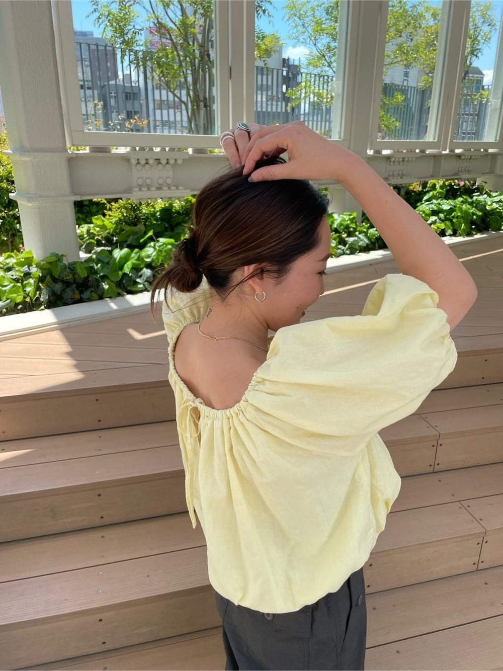 イエロー系のシャツ/ブラウス、ブラック系のサンダル、グレー系のその他パンツを着用したレディースの春コーディネートの6枚目の写真