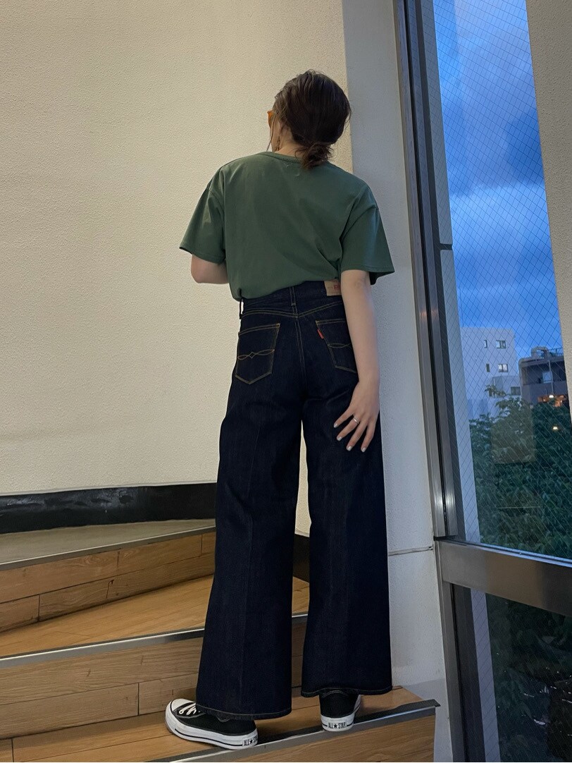 グリーン系のTシャツ/カットソー、ブルー系のデニムパンツ、ブラウン系のピアス（両耳用）を着用したレディースの春コーディネートの5枚目の写真