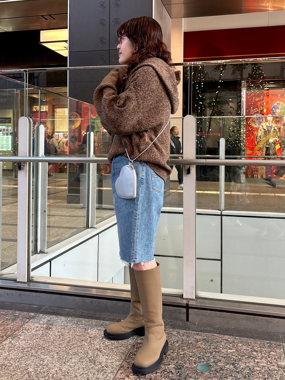 ブラウン系のニット/セーター、ブルー系のデニムパンツ、シルバー系のショルダーバッグを着用したレディースの秋コーディネートの3枚目の写真