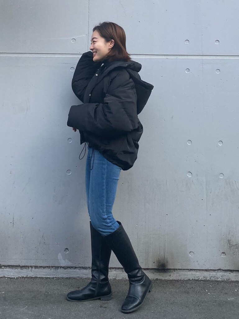 ブルー系のデニムパンツ、ブラック系のダウンジャケット/コートを着用したレディースの冬コーディネートの4枚目の写真