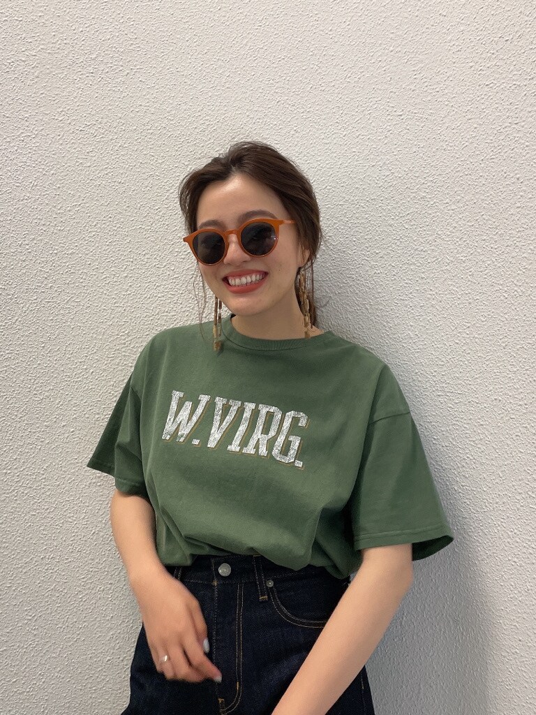 グリーン系のTシャツ/カットソー、ブルー系のデニムパンツ、ブラウン系のピアス（両耳用）を着用したレディースの春コーディネートの2枚目の写真