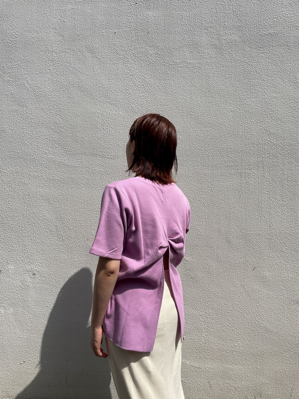 ホワイト系のスカート、パープル系のTシャツ/カットソー、ホワイト系のスニーカーを着用したレディースの春コーディネートの3枚目の写真