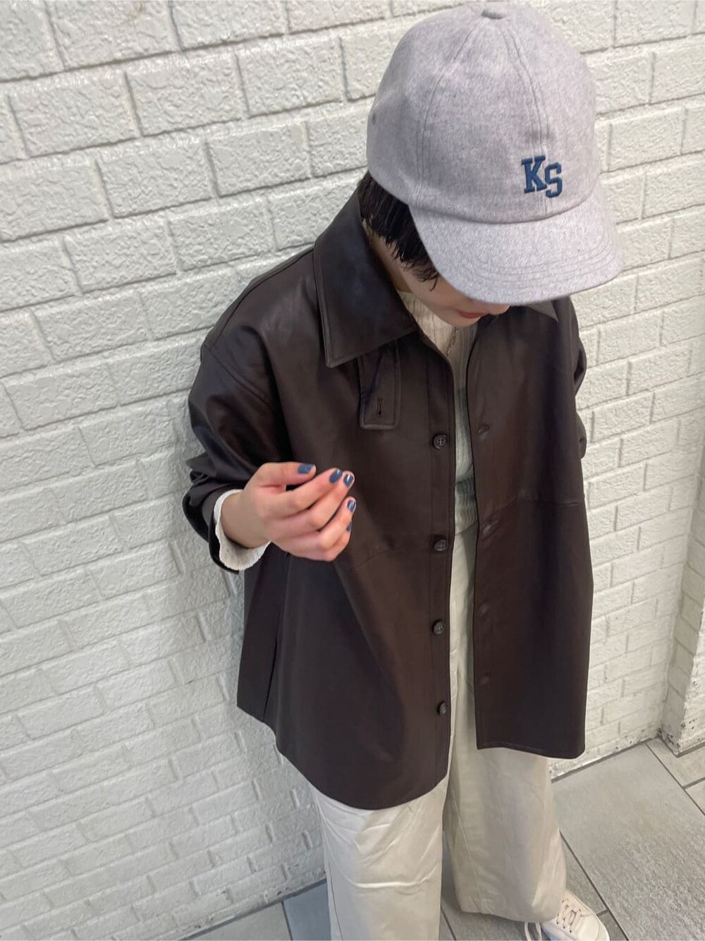 ホワイト系のニット/セーター、ブラウン系のハンドバッグ、ホワイト系のその他パンツを着用したレディースの秋コーディネートの5枚目の写真