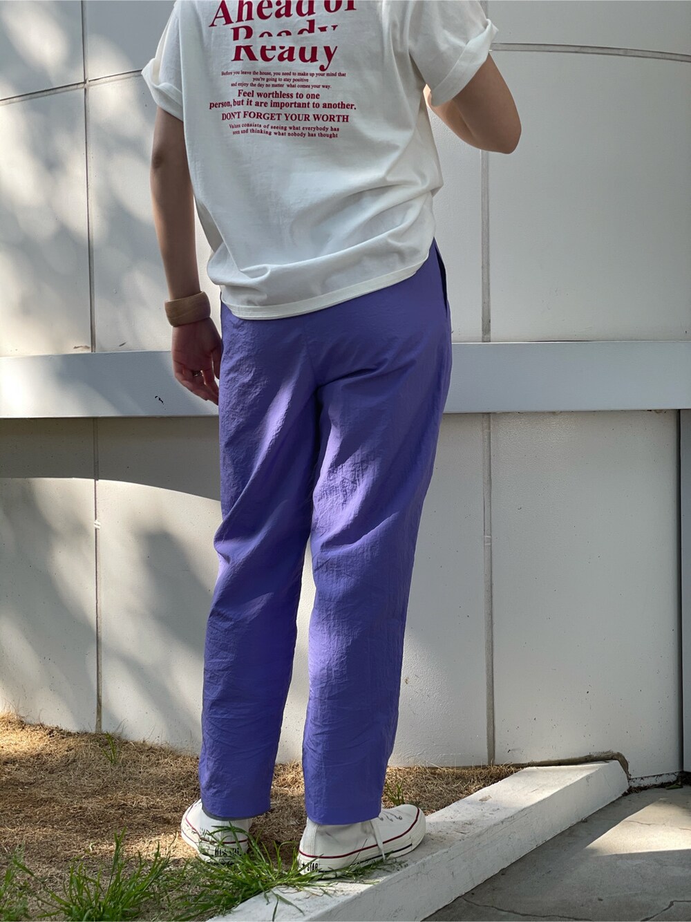 ホワイト系のTシャツ/カットソー、パープル系のその他パンツ、ベージュ系のブレスレットを着用したレディースの春コーディネートの5枚目の写真