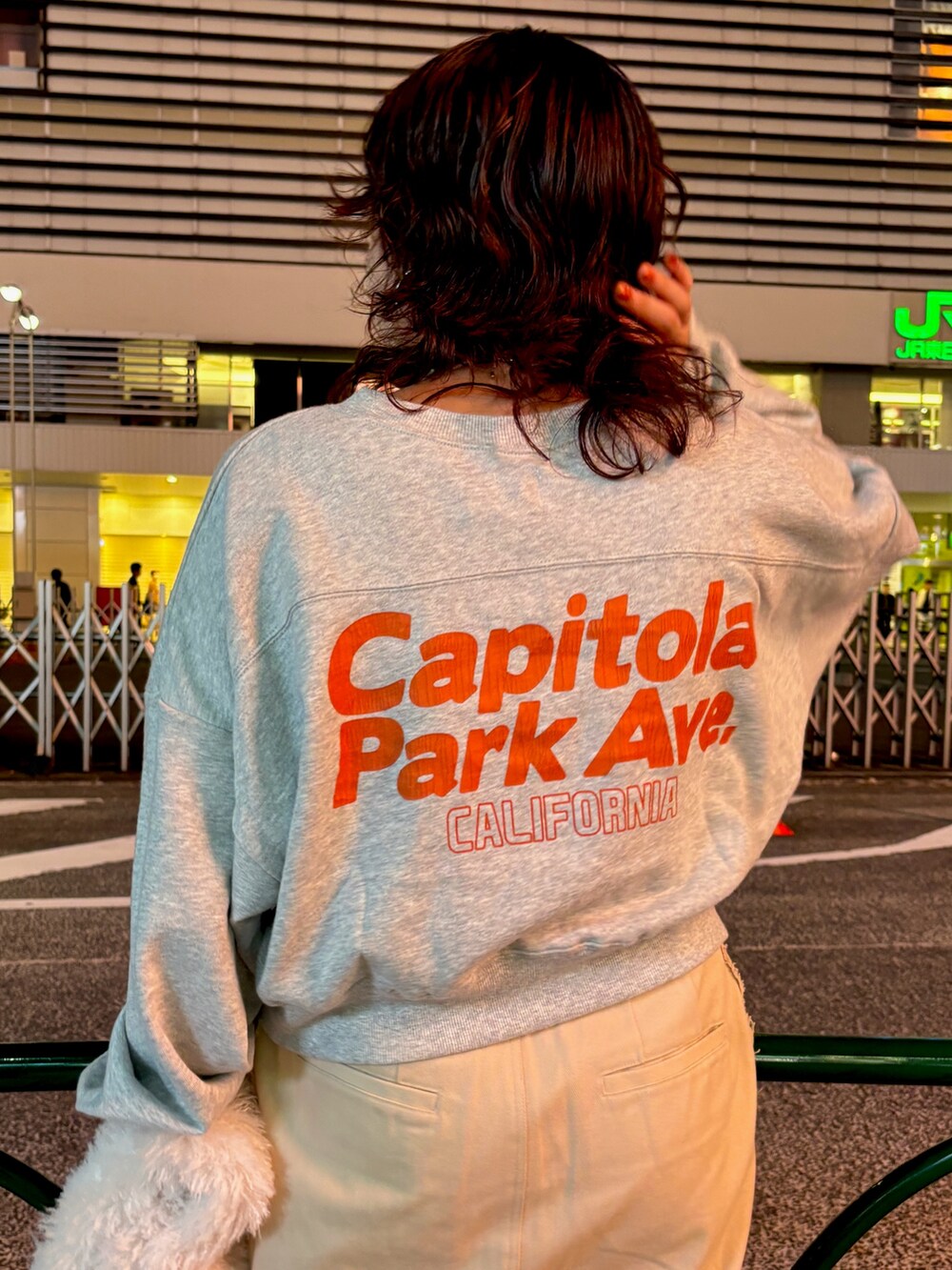 グレー系のスウェット、ベージュ系のスカート、ホワイト系のハンドバッグを着用したレディースの秋コーディネートの4枚目の写真