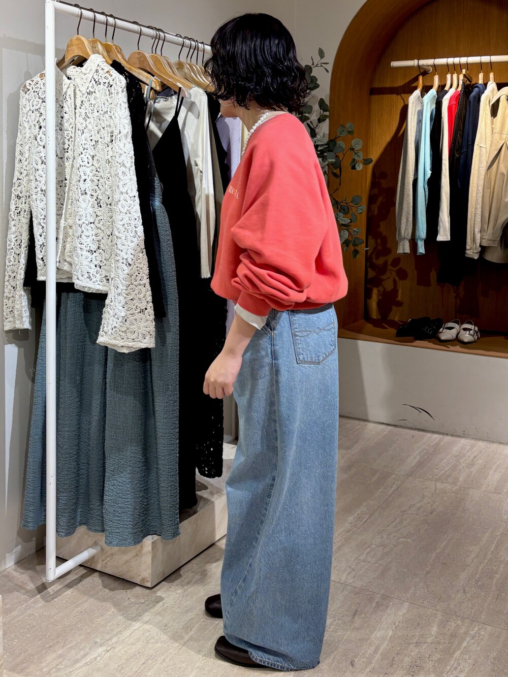 ブルー系のデニムパンツ、レッド系のスウェットを着用したレディースの冬コーディネートの2枚目の写真