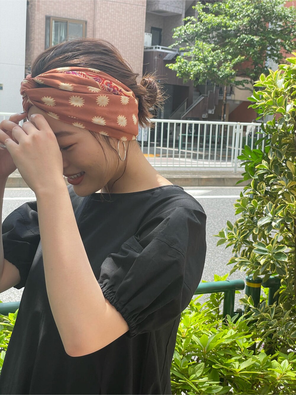 ブラック系のワンピース、ブラック系のサンダル、オレンジ系のストール/ショールを着用したレディースの夏コーディネートの5枚目の写真