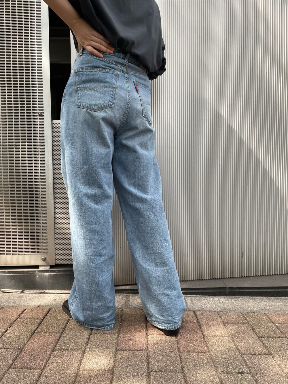 ブラック系のTシャツ/カットソー、ブルー系のデニムパンツ、ブラック系のブーツを着用したレディースの夏コーディネートの4枚目の写真