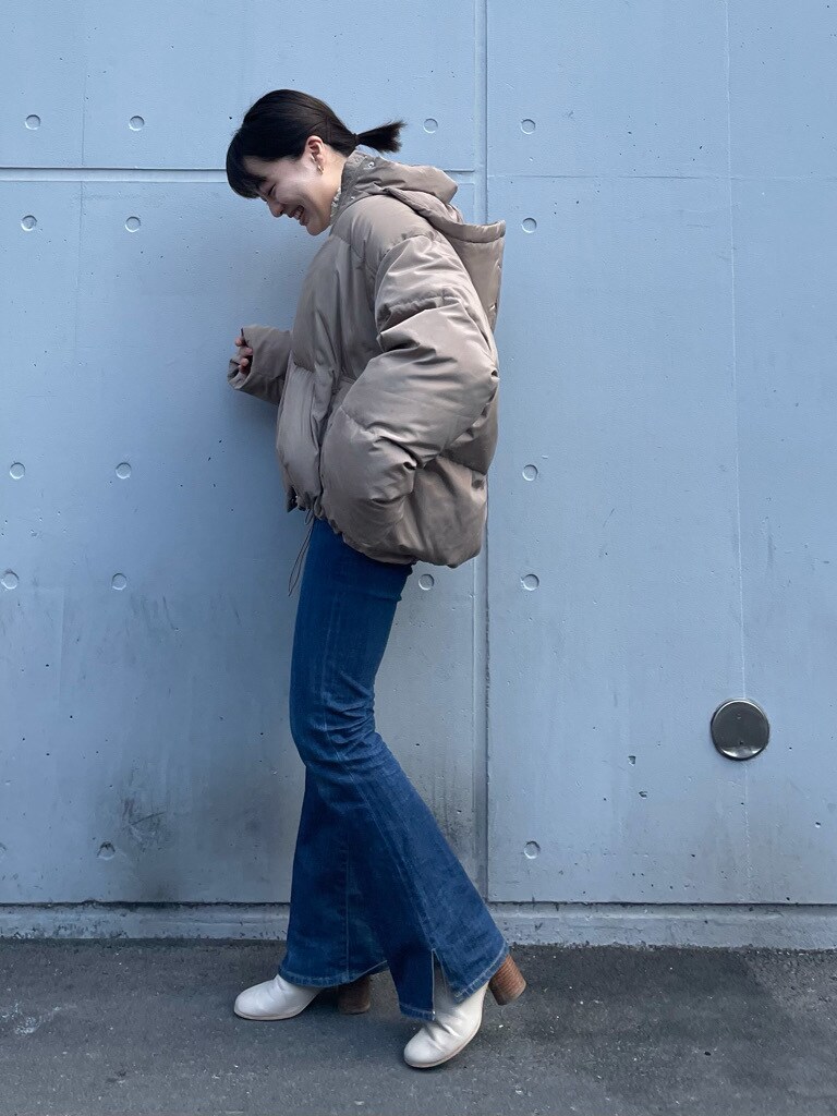 ブルー系のデニムパンツ、ベージュ系のダウンジャケット/コートを着用したレディースの冬コーディネートの2枚目の写真