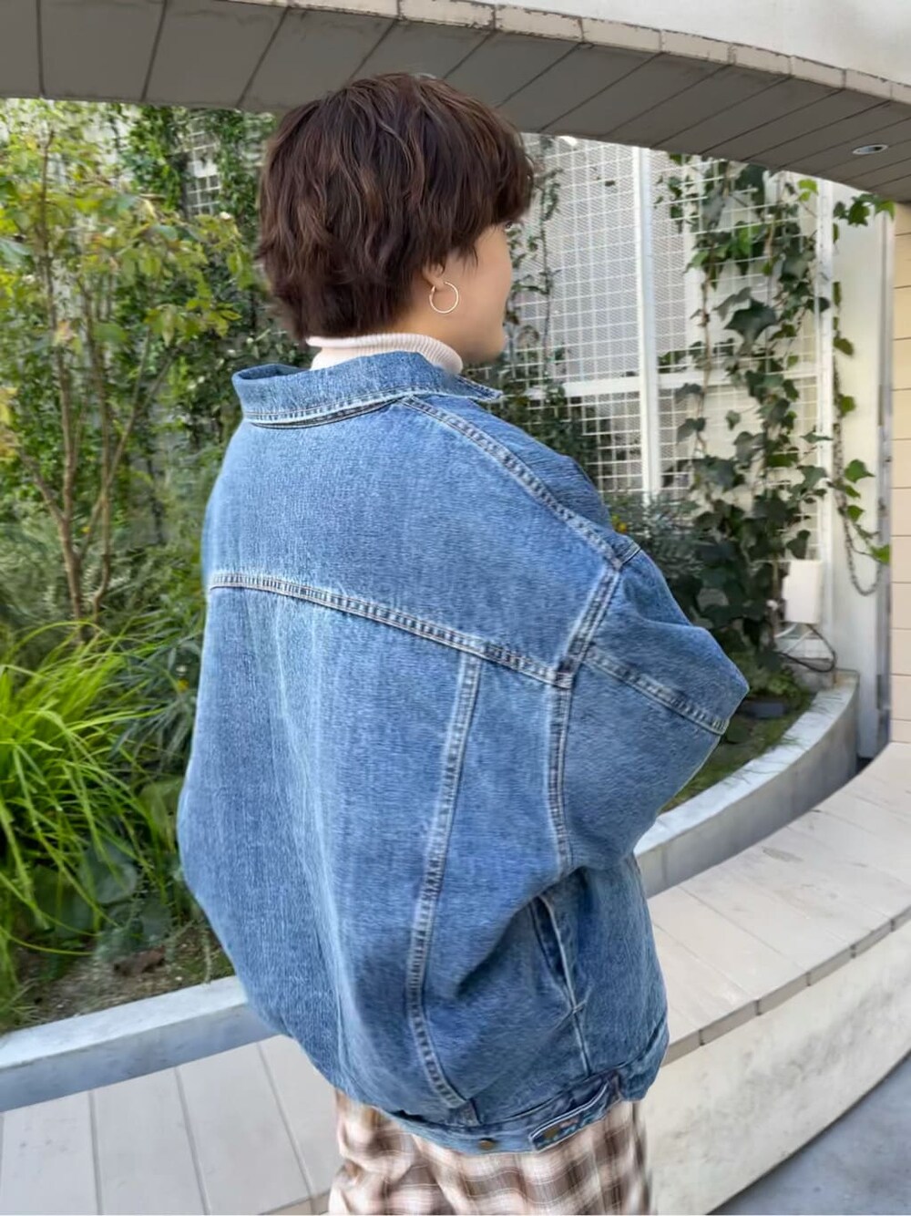 ブルー系のデニムジャケット、ホワイト系のニット/セーター、ブラウン系のその他パンツを着用したレディースの秋コーディネートの5枚目の写真