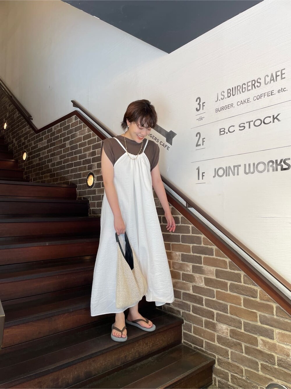 ホワイト系のワンピース、ブラウン系のタンクトップを着用したレディースの夏コーディネートの3枚目の写真