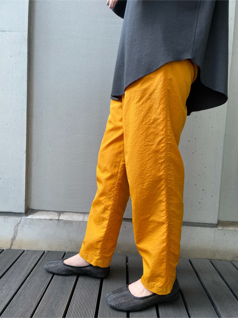 イエロー系のその他パンツ、グレー系のTシャツ/カットソー、ゴールド系のブレスレットを着用したレディースの春コーディネートの6枚目の写真