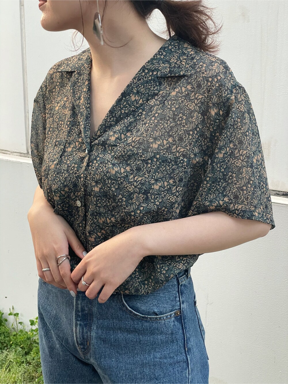 ブルー系のデニムパンツ、レッド系のシャツ/ブラウス、ブラック系のサンダルを着用したレディースの春コーディネートの4枚目の写真