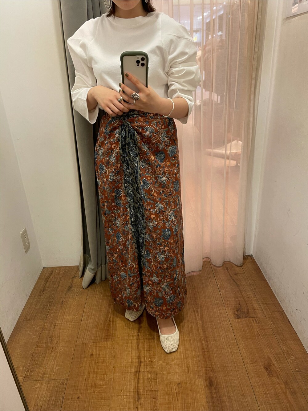 オレンジ系のスカート、ホワイト系のTシャツ/カットソーを着用したレディースの冬コーディネートの3枚目の写真