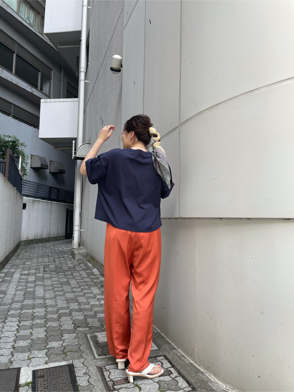 ブルー系のTシャツ/カットソー、オレンジ系のその他パンツ、イエロー系のストール/ショールを着用したレディースの春コーディネートの3枚目の写真