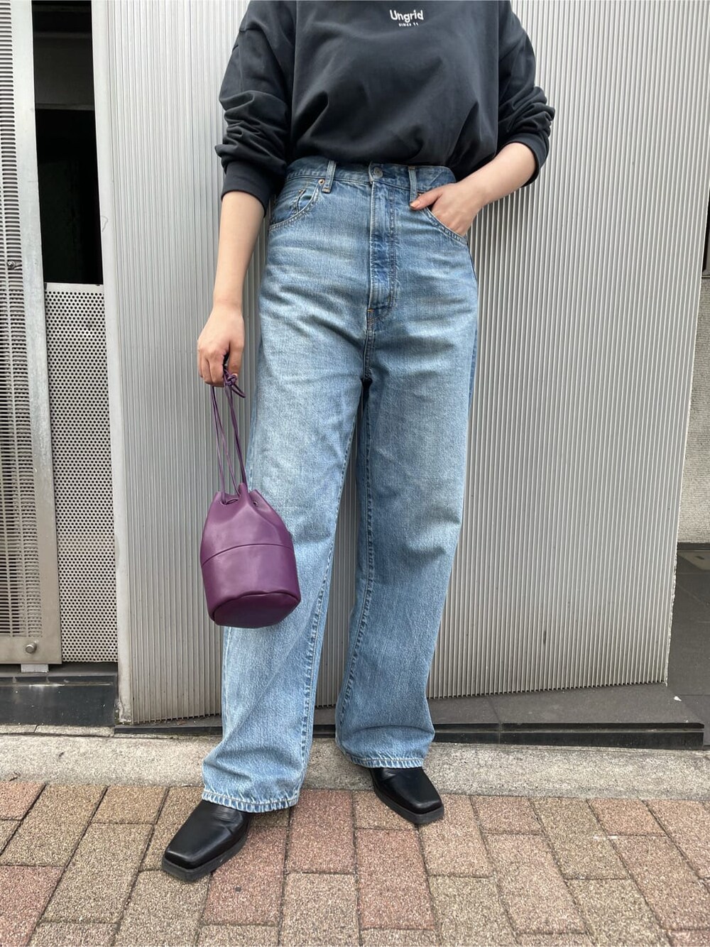 ブラック系のTシャツ/カットソー、ブルー系のデニムパンツ、ブラック系のブーツを着用したレディースの夏コーディネートの3枚目の写真