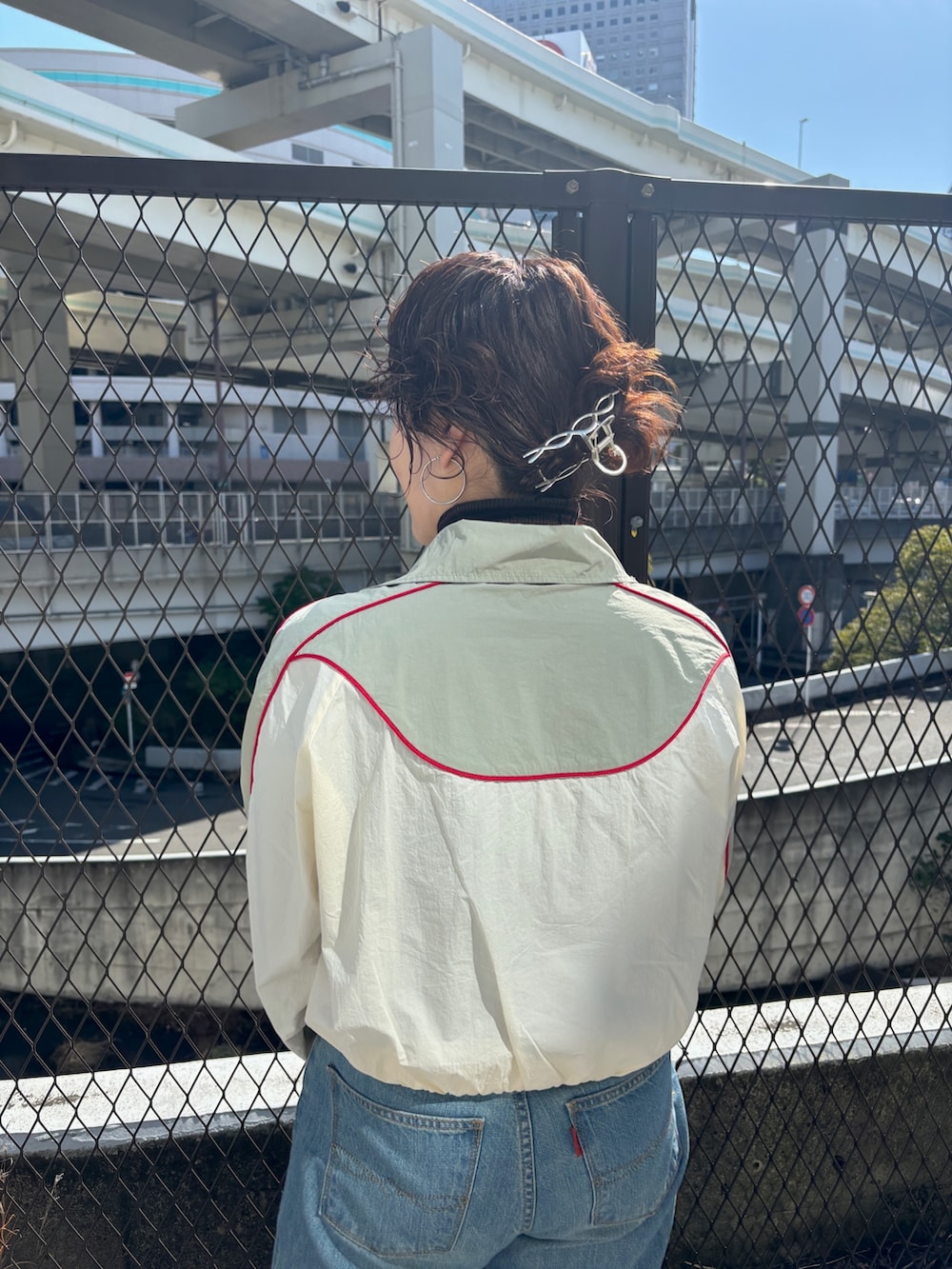 ブラック系のステンカラーコート、ホワイト系のブルゾンを着用したレディースの冬コーディネートの7枚目の写真