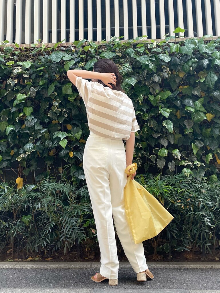 ホワイト系のその他パンツ、ブラウン系のサンダル、イエロー系のハンドバッグを着用したレディースの春コーディネートの6枚目の写真