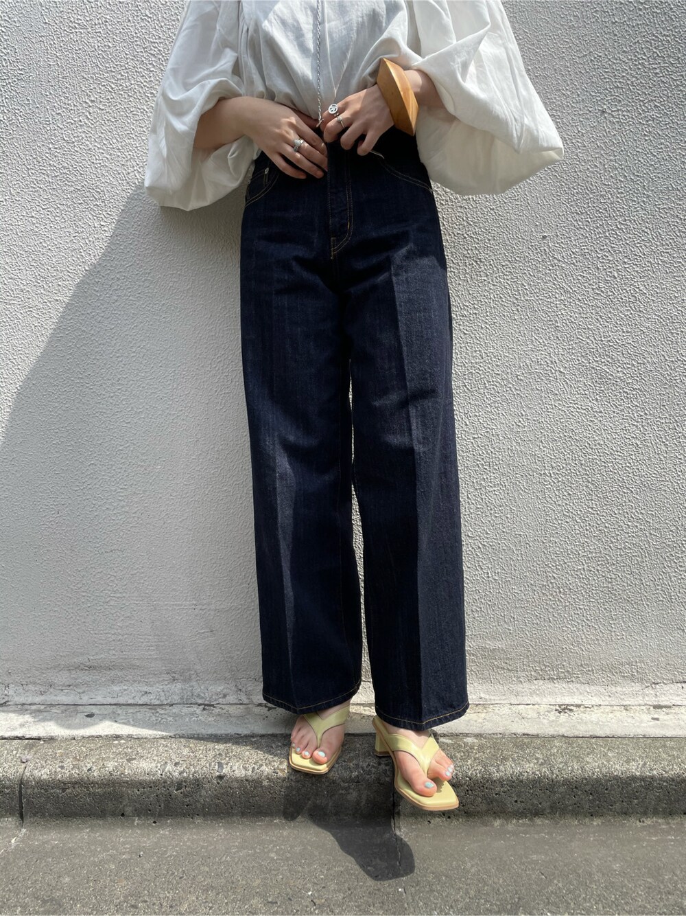 ホワイト系のシャツ/ブラウス、ブルー系のデニムパンツ、ベージュ系のバングル/リストバンドを着用したレディースの春コーディネートの3枚目の写真