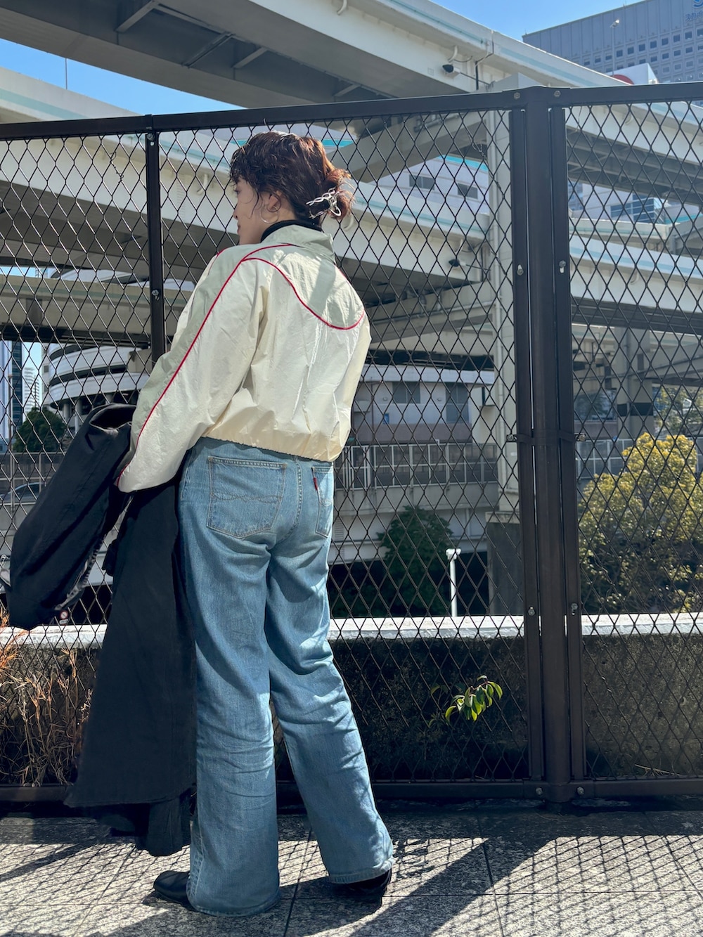 ブラック系のステンカラーコート、ホワイト系のブルゾンを着用したレディースの冬コーディネートの5枚目の写真