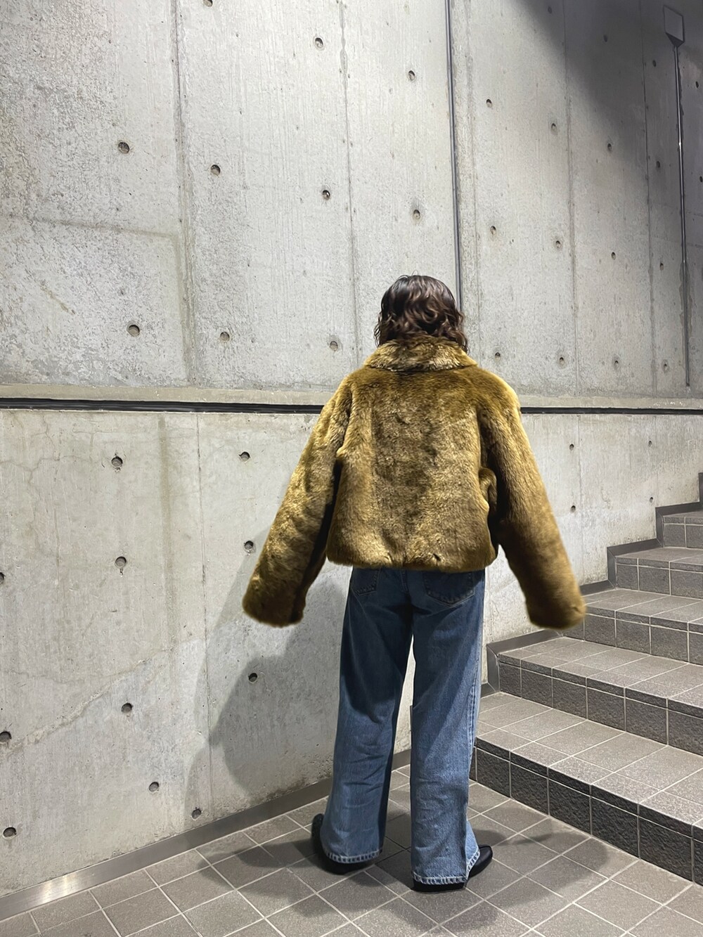 ブラウン系のブルゾン、ブルー系のデニムパンツを着用したレディースの秋コーディネートの5枚目の写真