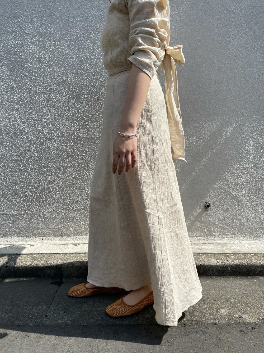 ホワイト系のワンピース、ホワイト系のタンクトップ、レッド系のピアス（両耳用）を着用したレディースの春コーディネートの3枚目の写真