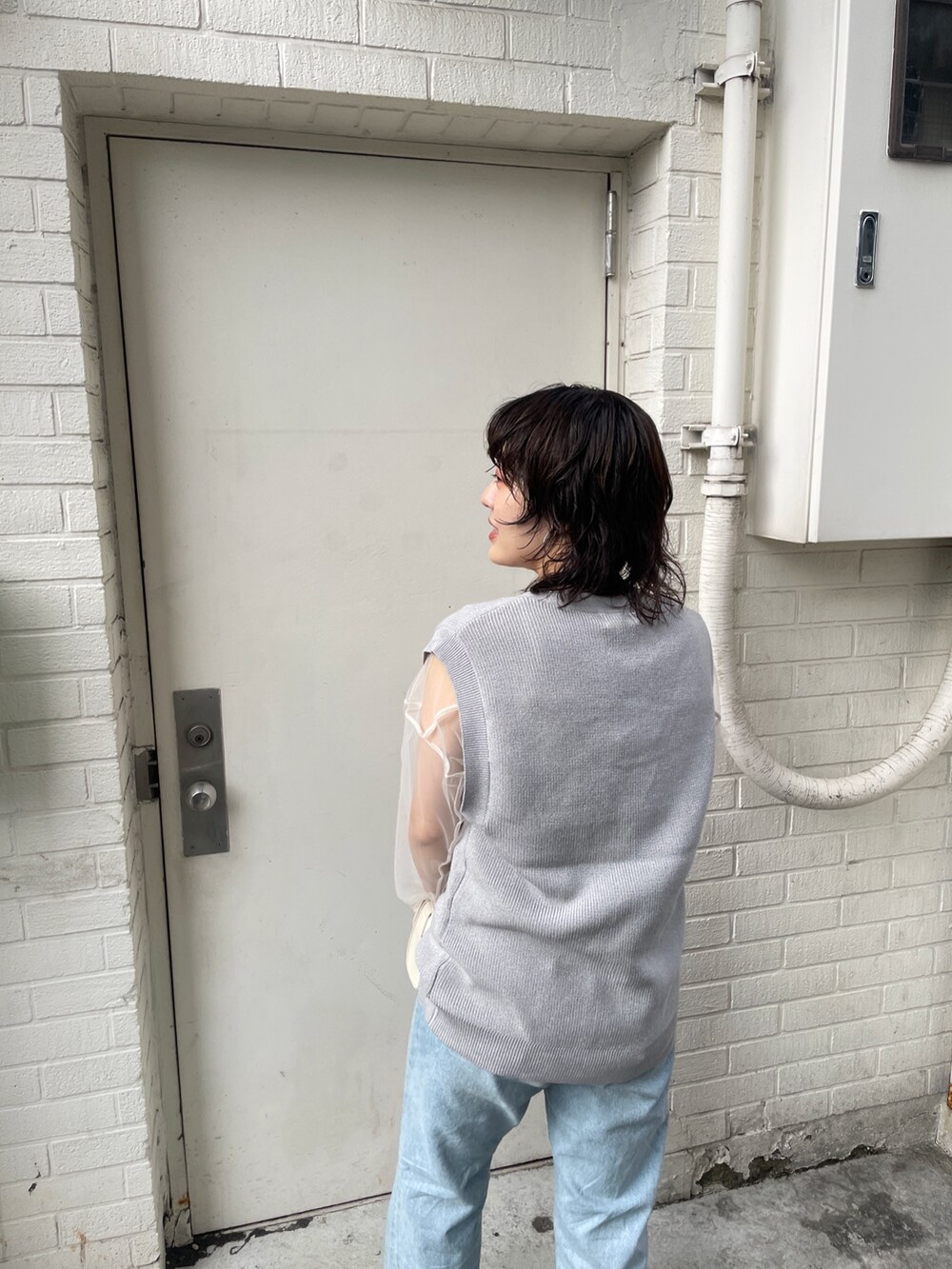 ブルー系のデニムパンツ、シルバー系のベスト、ホワイト系のTシャツ/カットソーを着用したレディースの夏コーディネートの5枚目の写真