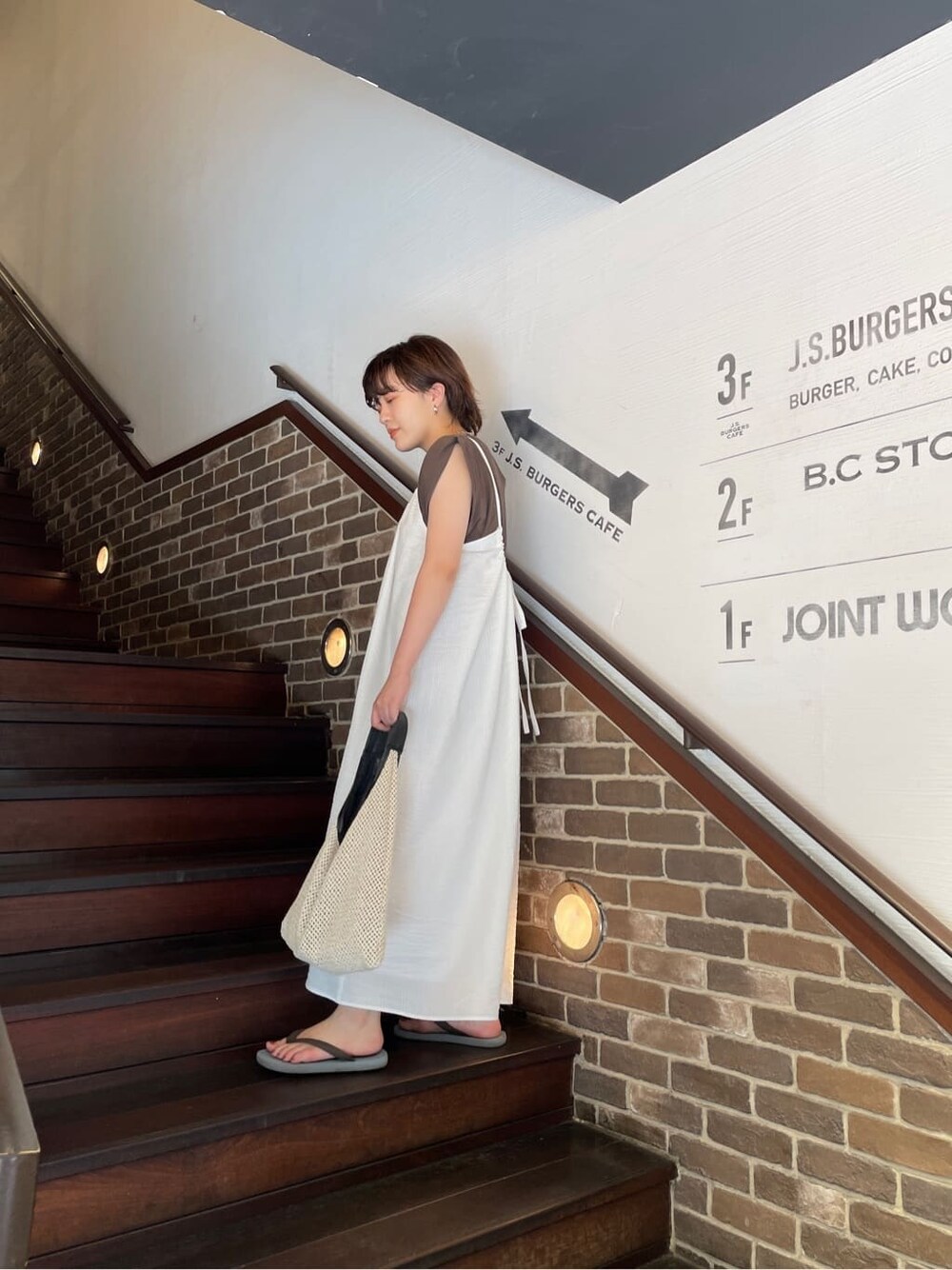 ホワイト系のワンピース、ブラウン系のタンクトップを着用したレディースの夏コーディネートの2枚目の写真