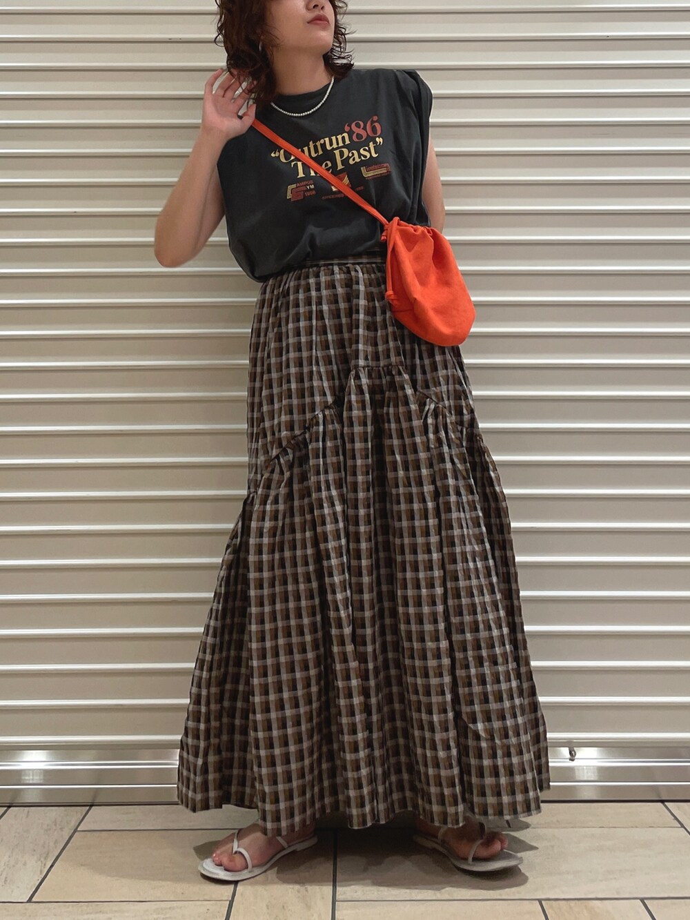 ブラウン系のスカート、グレー系のタンクトップを着用したレディースの夏コーディネートの2枚目の写真