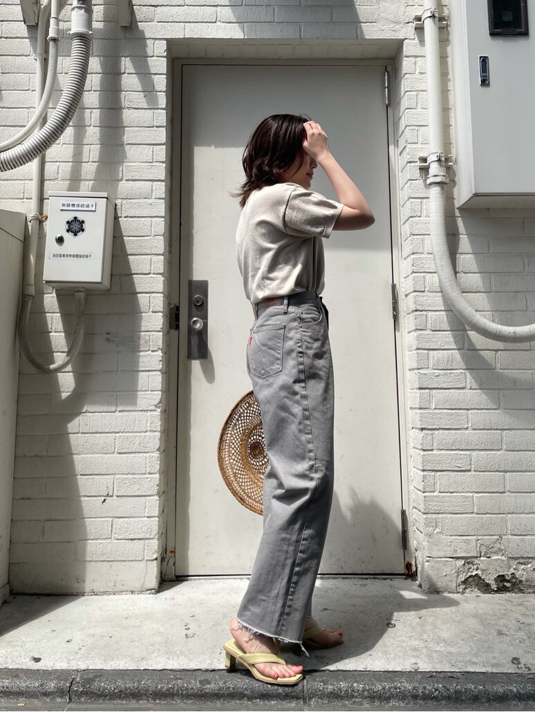 グレー系のデニムパンツ、ホワイト系のニット/セーター、ブラウン系のハットを着用したレディースの春コーディネートの2枚目の写真