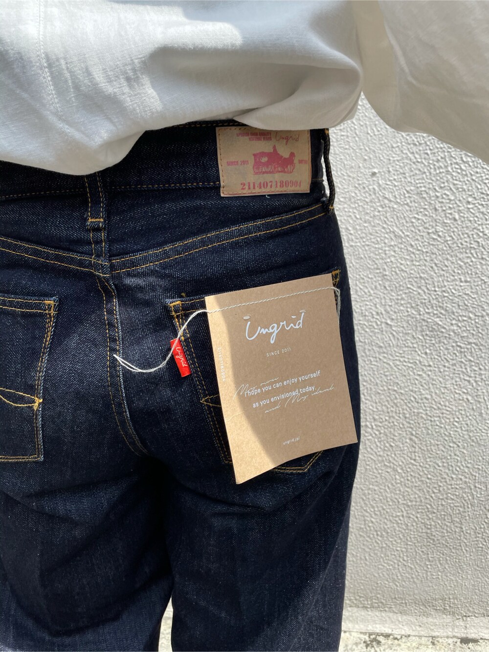 ホワイト系のシャツ/ブラウス、ブルー系のデニムパンツ、ベージュ系のバングル/リストバンドを着用したレディースの春コーディネートの6枚目の写真