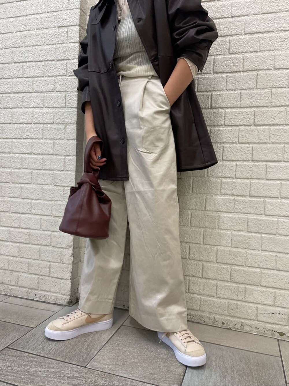 ホワイト系のニット/セーター、ブラウン系のハンドバッグ、ホワイト系のその他パンツを着用したレディースの秋コーディネートの3枚目の写真