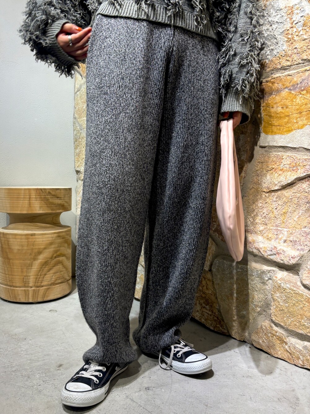 グレー系のニット/セーター、グレー系のその他パンツ、ピンク系のハンドバッグを着用したレディースの秋コーディネートの6枚目の写真
