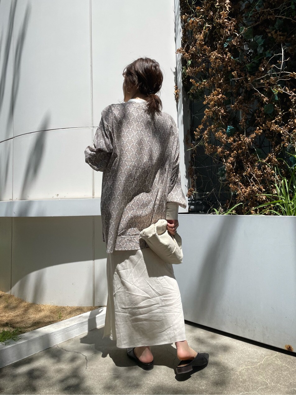 ホワイト系のスカート、ホワイト系のクラッチバッグを着用したレディースの春コーディネートの5枚目の写真