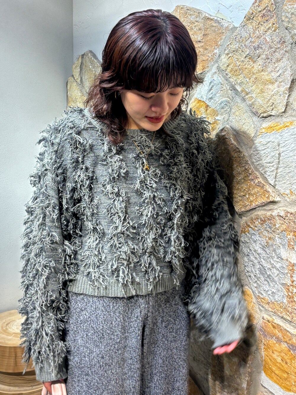 グレー系のニット/セーター、グレー系のその他パンツ、ピンク系のハンドバッグを着用したレディースの秋コーディネートの4枚目の写真