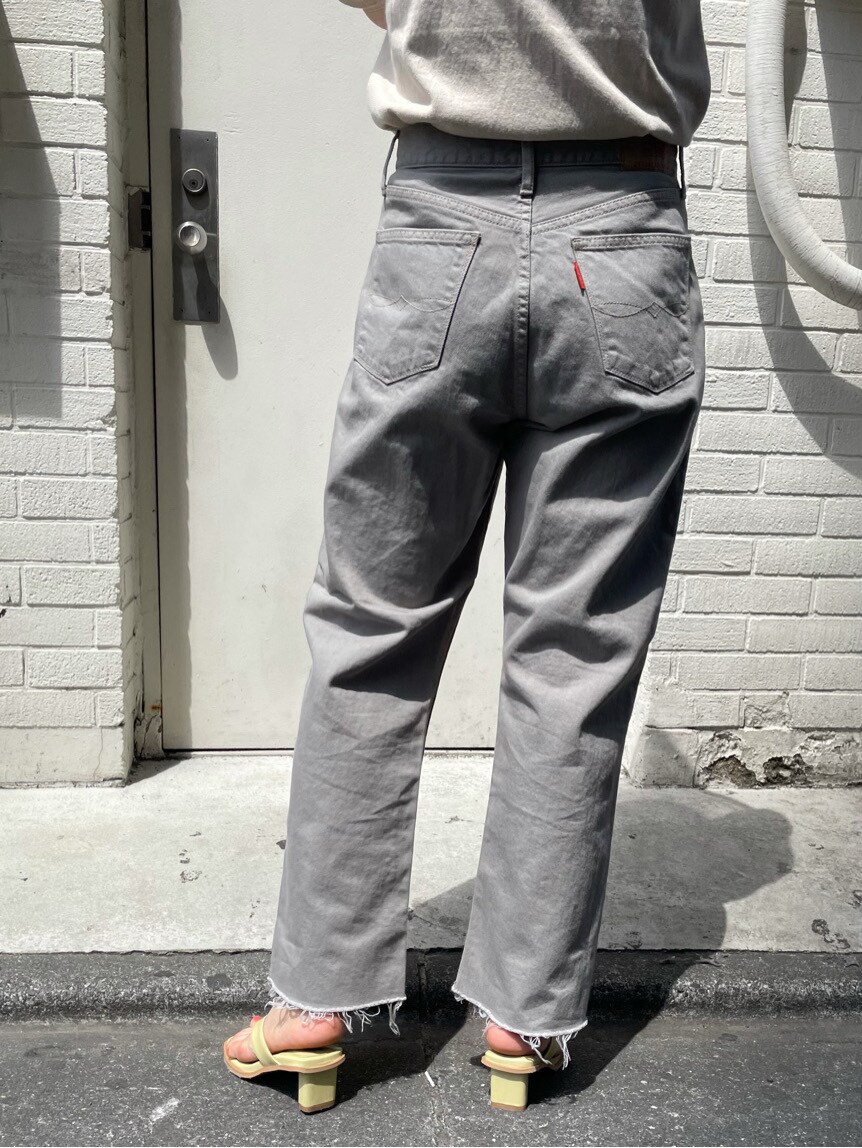グレー系のデニムパンツ、ホワイト系のニット/セーター、ブラウン系のハットを着用したレディースの春コーディネートの4枚目の写真