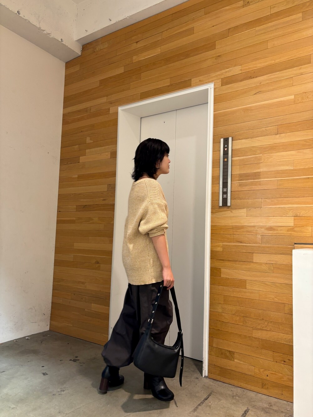 ベージュ系のカーディガン/ボレロ、グレー系のその他パンツ、ブラック系のショルダーバッグを着用したレディースの冬コーディネートの3枚目の写真