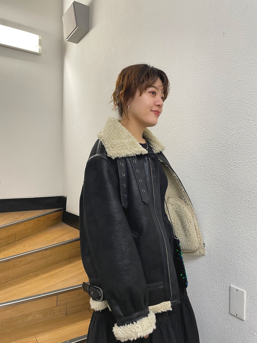 ブラック系のムートンコート、ブラック系のワンピースを着用したレディースの秋コーディネートの5枚目の写真