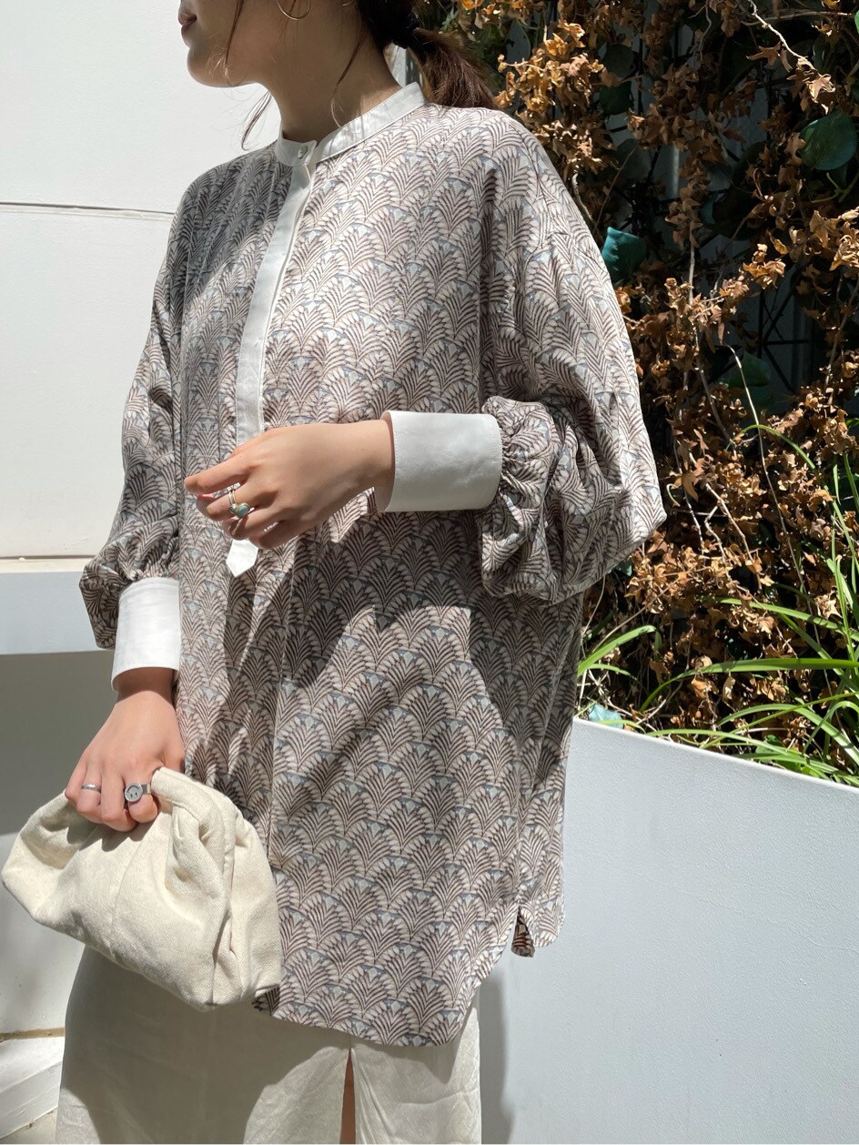 ホワイト系のスカート、ホワイト系のクラッチバッグを着用したレディースの春コーディネートの2枚目の写真