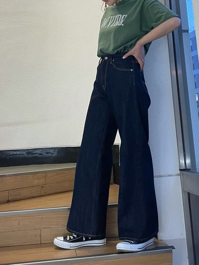 グリーン系のTシャツ/カットソー、ブルー系のデニムパンツ、ブラウン系のピアス（両耳用）を着用したレディースの春コーディネートの4枚目の写真