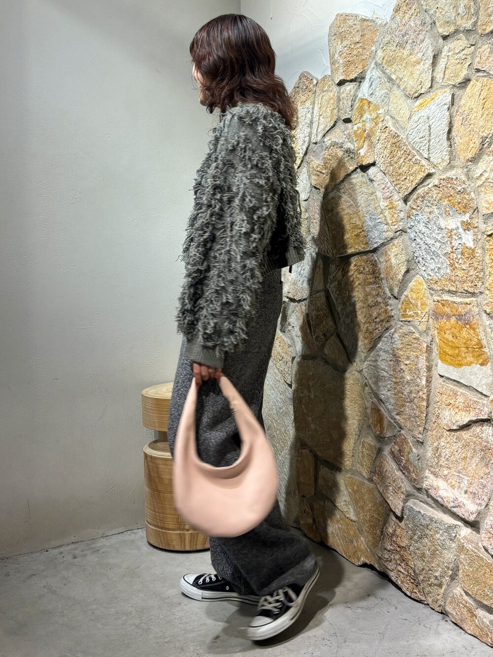 グレー系のニット/セーター、グレー系のその他パンツ、ピンク系のハンドバッグを着用したレディースの秋コーディネートの2枚目の写真