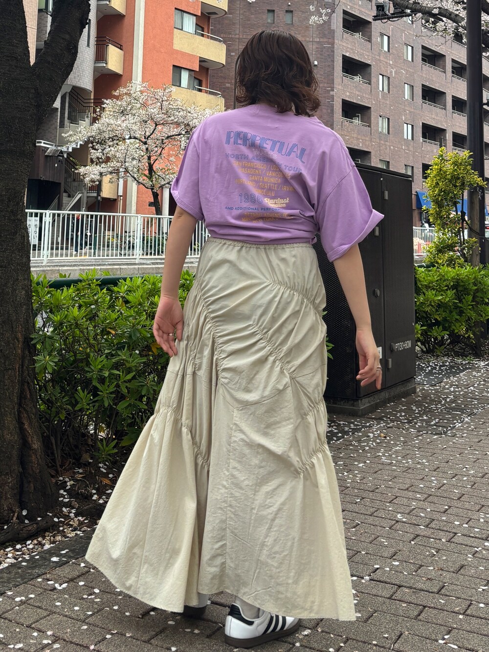パープル系のTシャツ/カットソー、ホワイト系のスカートを着用したレディースの春コーディネートの3枚目の写真
