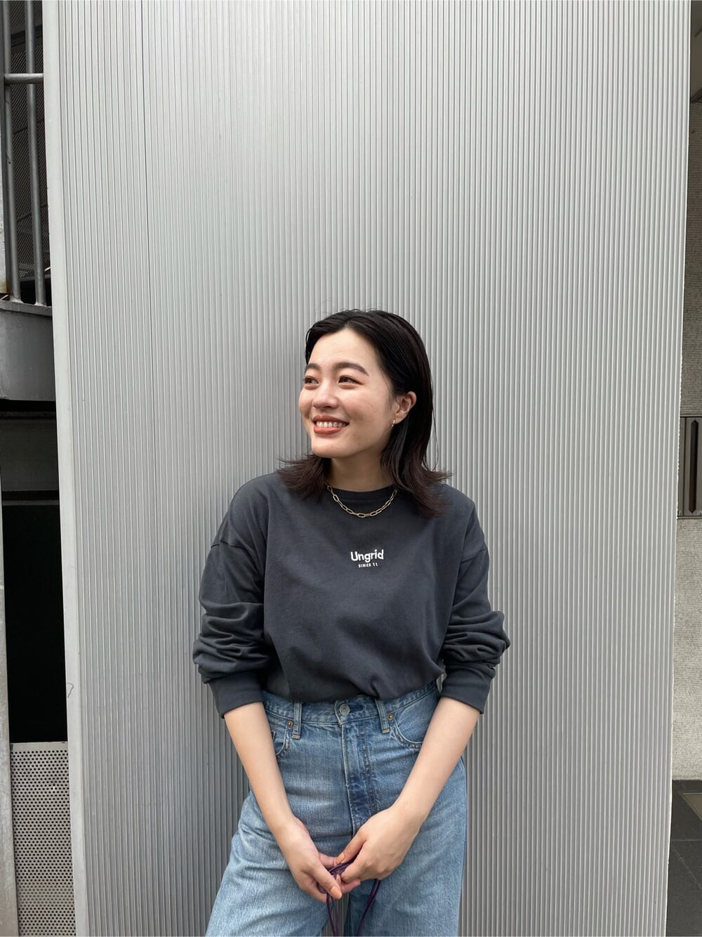 ブラック系のTシャツ/カットソー、ブルー系のデニムパンツ、ブラック系のブーツを着用したレディースの夏コーディネートの6枚目の写真