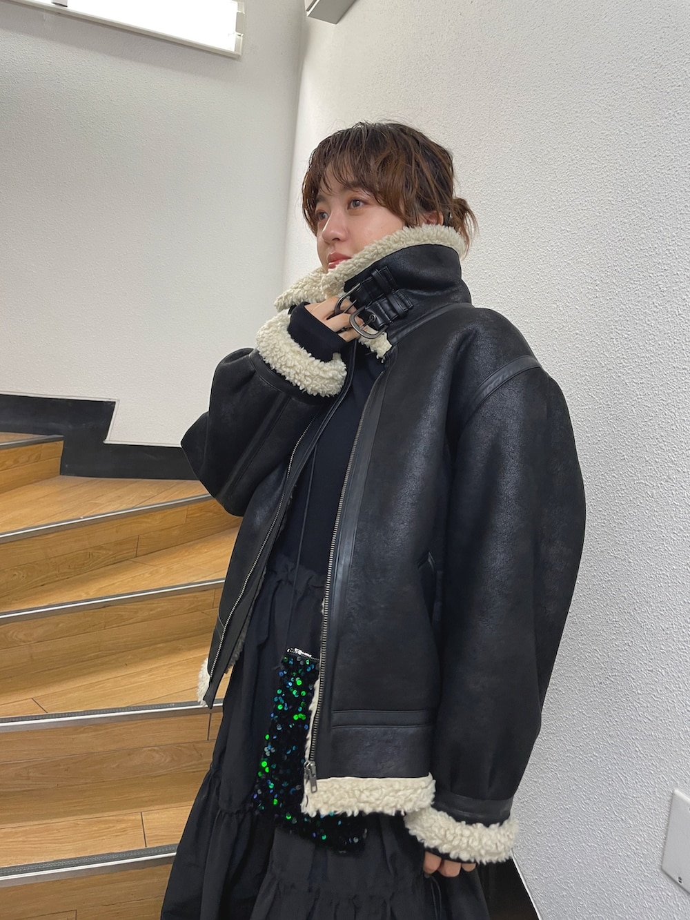ブラック系のムートンコート、ブラック系のワンピースを着用したレディースの秋コーディネートの4枚目の写真