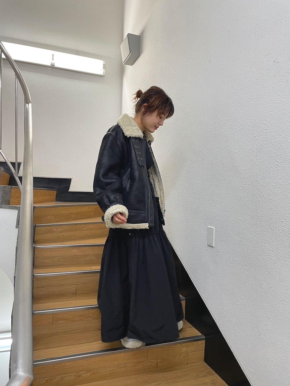 ブラック系のムートンコート、ブラック系のワンピースを着用したレディースの秋コーディネートの2枚目の写真