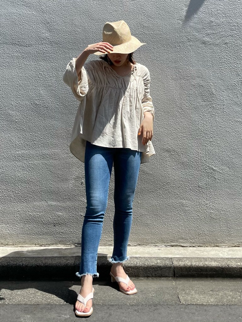 ホワイト系のシャツ/ブラウス、ブルー系のデニムパンツ、ブラウン系のピアス（両耳用）を着用したレディースの春コーディネートの4枚目の写真